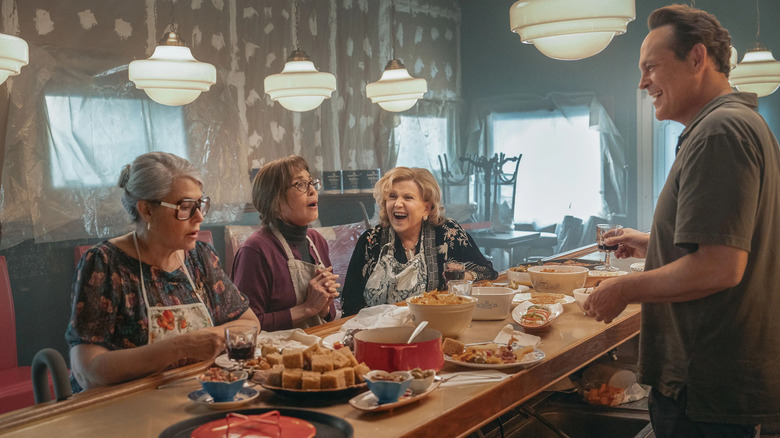 Lorraine Bracco ca Roberta, Talia Shire ca Teresa și Brenda Vaccaro în rolul lui Antonella stând pe un blat în fața lui Vince Vaughn ca Joe Scaravella în NonNas