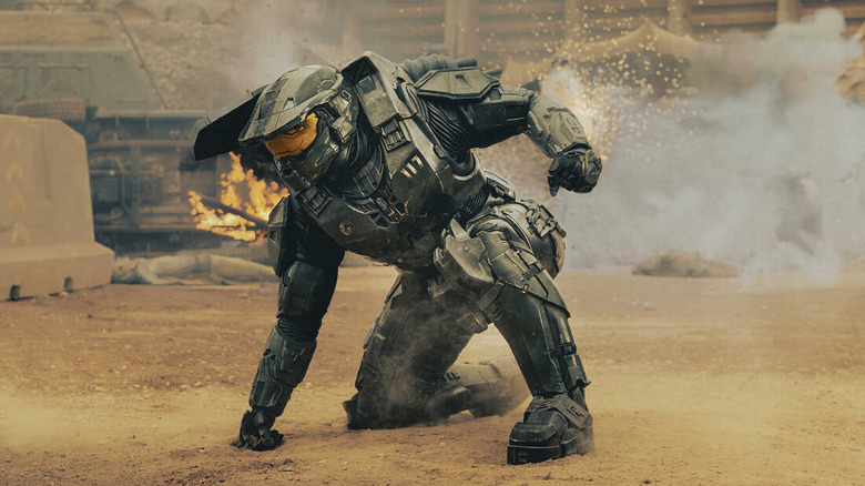 Maestrul șef își lovește poza de semnătură, un braț plantat în pământ, celălalt gata să se lupte, în Halo