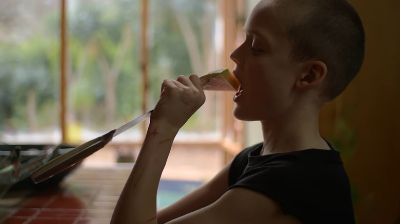 Oliver ține un cuțit de bucătărie cu cantaloupe la capătul său, aduc -o înapoi