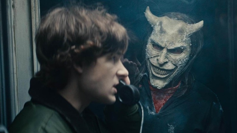 Mason Thames pe telefonul negru cu apucarea în afara cabinei de telefon