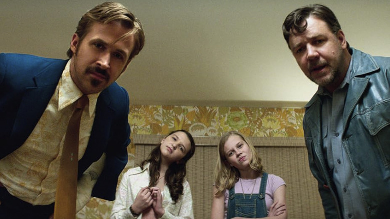 Holland March și Jackson Healy se apleacă spre aparatul foto și se uită în jos pe obiectiv, cu Holly și prietenul ei făcând același lucru în fundal într -o lovitură de la băieții drăguți