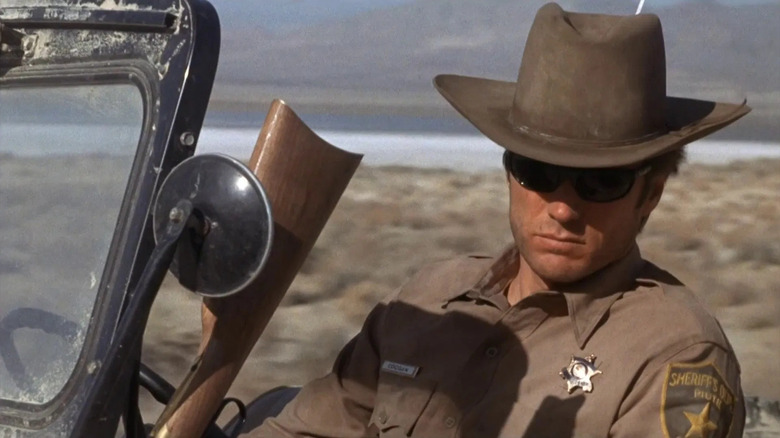 Clint Eastwood în rolul lui Walt Coogan conducând un jeep prin deșert în Coogan's Bluff
