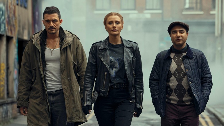 Orlando Bloom ca Marlon Swift, Bryce Dallas Howard ca Kat Boyles și Nick Mohammed, în timp ce Hugh coboară pe o alee aburită în acoperire profundă