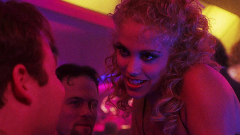 Nomi Malone privind securtiv la un client al clubului de striptease din showgirls