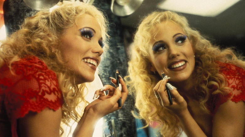 Nomi Malone zâmbind și punând machiaj în showgirls