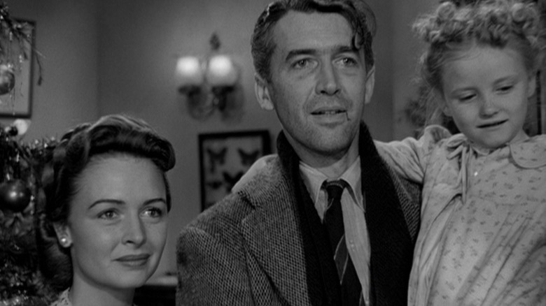 George Bailey Holdinh o fată, lângă soția sa, este o viață minunată.