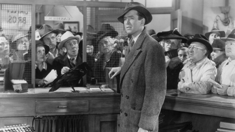 George Bailey la banca de lângă o cioara, cu o mulțime care se uită în ea este o viață minunată.
