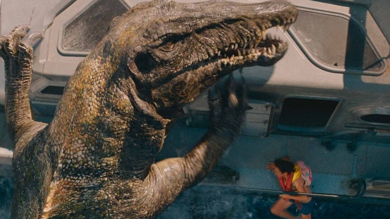Un spinosaur dopey se apucă pe o barcă pentru a încerca să mănânce un om în Jurassic World Rebirth