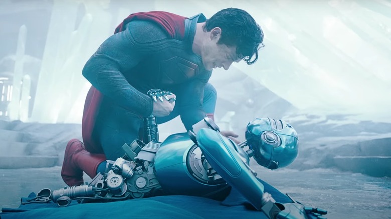 Superman a îngenuncheat peste un robot deteriorat în cetatea Solitudinii din Superman