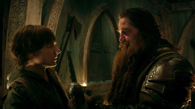 Sughiț privindu -se spre tatăl său Stoick, vastul din interiorul unei săli de viking, în modul de a -ți antrena dragonul