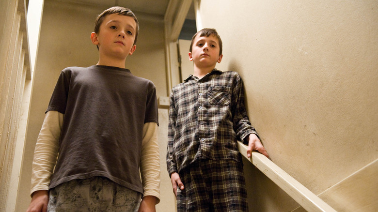 Jason și Marcus stând pe o scară în continuare