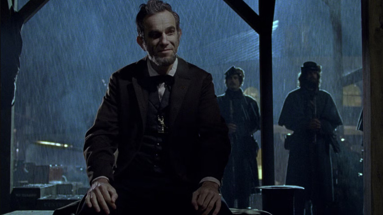 Lincoln (Daniel Day-Lewis) zâmbind în ploaie în Lincoln