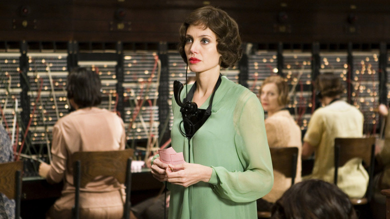 Christine Collins într-un aparat telefonic montat pe gât, arătând contemplativ în Changeling