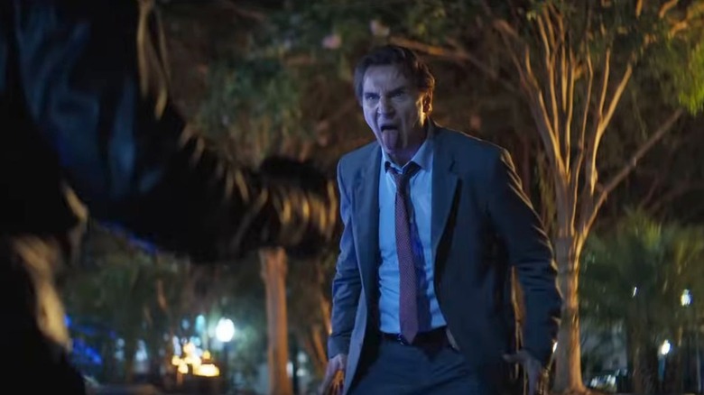 Liam Neeson în timp ce Frank Drebin pune o față stupidă în arma goală