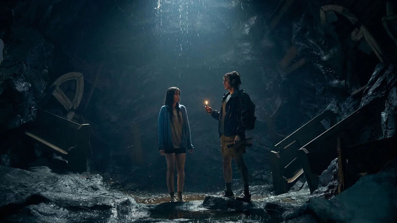 Millie și Tim stând într -o peșteră împreună