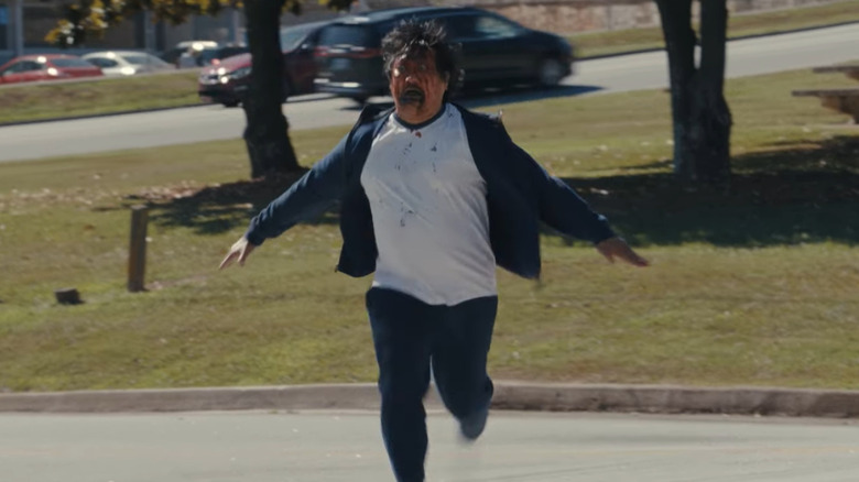 Benedict Wong ca Andrew alergând spre Justine cu o față sângeroasă în arme