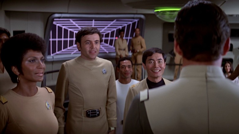 Uhura, Chekov și Sulu salută amiralul Kirk pe podul întreprinderii