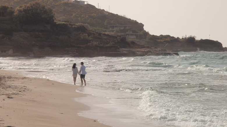 Anna de la Vega a lui Sofia Carson se plimbă de -a lungul unui țărm cu Jamie Davenport de Corey Mylchreest în anul meu Oxford