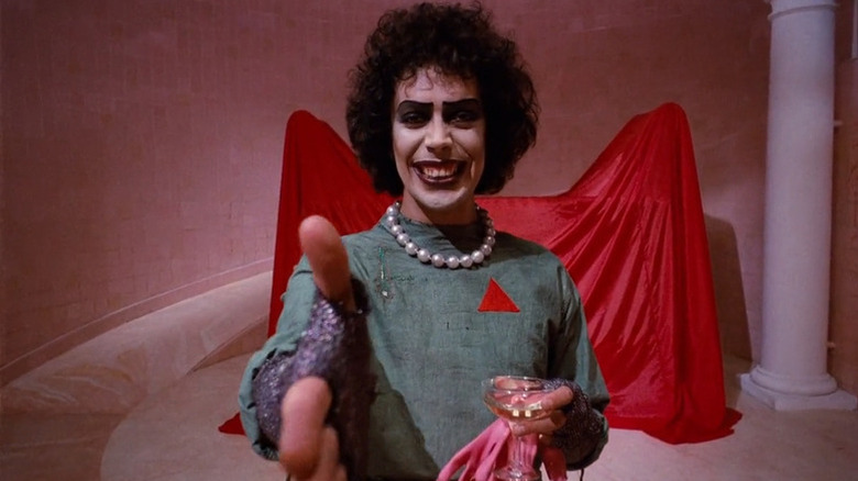 Frank-n-Furter ajungând la mâna la cameră