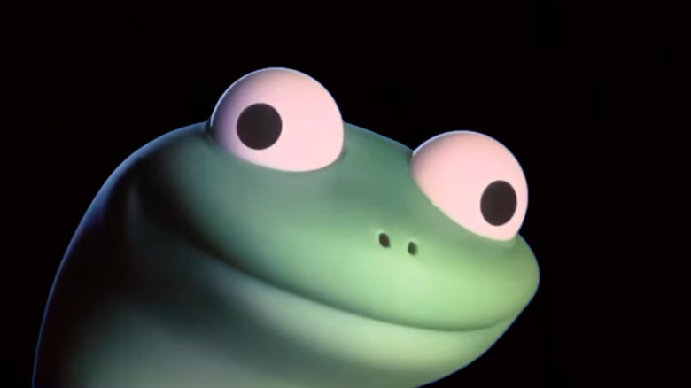 Ochii lui Tom șopârla privesc în două direcții diferite, în timp ce are un zâmbet mare pe fața lui verde "Hoppers"