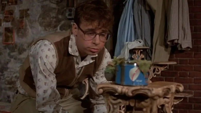 Seymour Krelborn (Rick Moranis) își monitorizează uzina, Audrey II (Levi Stubbs) în 
