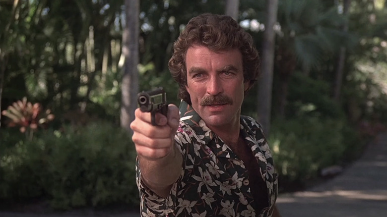 Tom Selleck în timp ce Thomas Magnum își indică pistolul în Magnum, pi