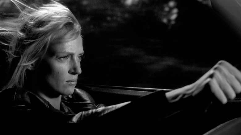 Uma Thurman, în calitate de Beatrix Kiddo, conducând o mașină în alb și negru în Kill Bill Vol. 2