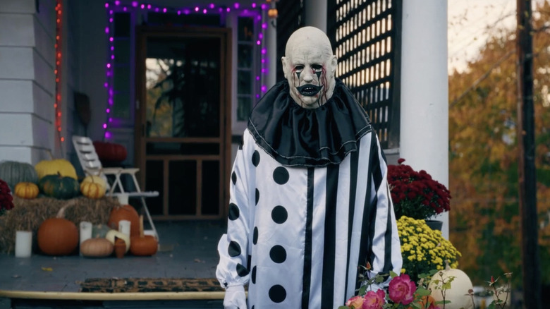 Unul din Hell House LLC Clowns stă în fața decorațiunilor de Halloween în Hell House LLC: Lineage