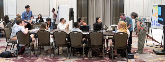 Participanții la sesiune în jurul unei reflecții de masă și împărtășind despre bariere și obstacole pentru a se angaja pentru dezvoltarea de software de știință și cercetare