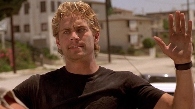 Brian arătând dur, ridicând mâinile în post și furios