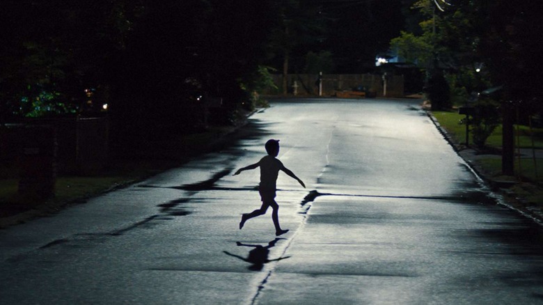 Un copil care alerga peste stradă în arme