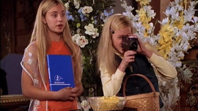 Kaley Cuoco în rolul lui Maureen McCormick și Kaitlin Cullum Aseve Plumb cu o cameră foto pe setul Brady Bunch în creșterea lui Brady