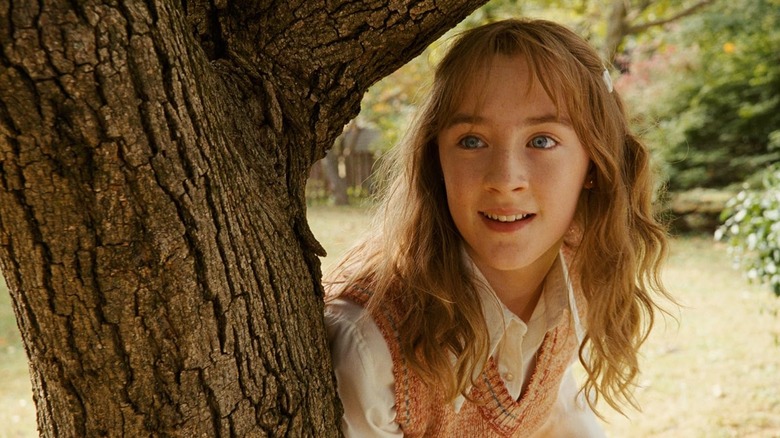 Saoirse Ronan ca Susie Salmon care stă în spatele unui copac din oasele minunate