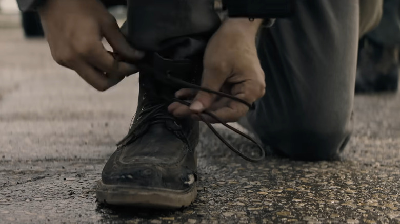 Un personaj care își leagă pantoful în lungă plimbare