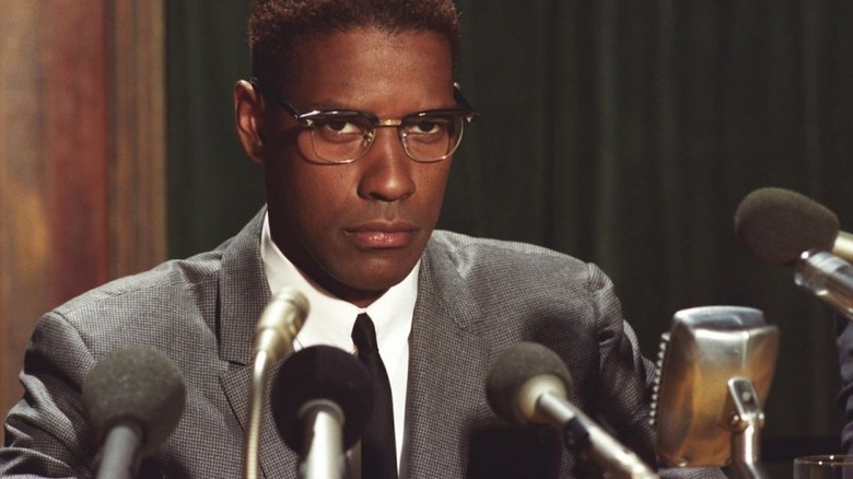 Denzel Washington își fixează ochii pe cameră ca Malcolm X în Malcolm X