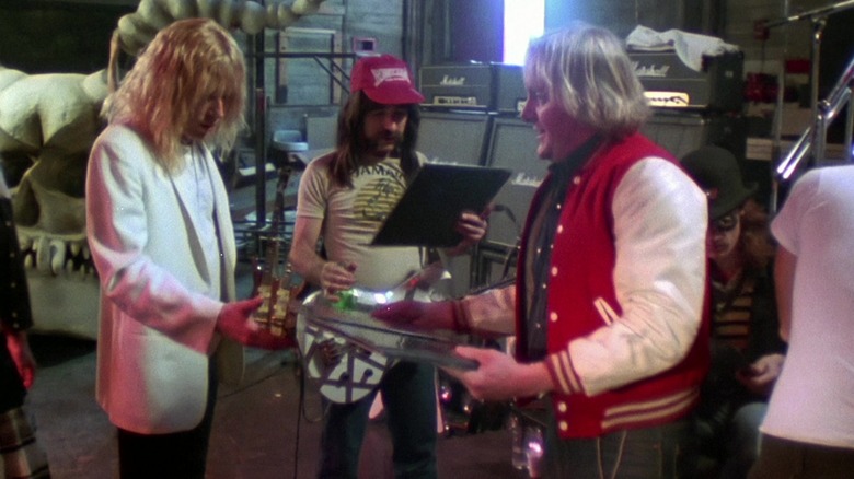 Derek Smalls și David St. Hubbins și managerul lor care se uită la toate recordurile negre din acest lucru este spinal tap