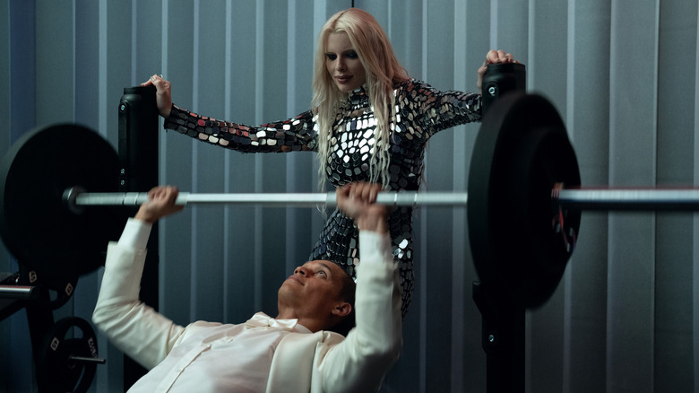 Cam ridică greutăți într -un tuxedo în timp ce Elsie privește în el