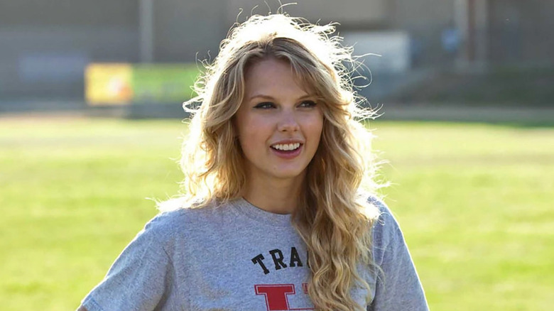 Felicia (Taylor Swift) zâmbind și stând în fața unei suprafețe ierboase în "Ziua Îndrăgostiților"