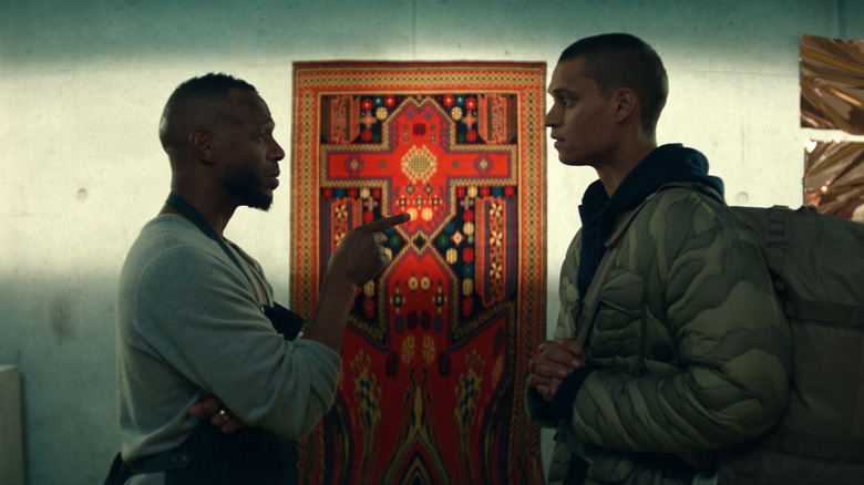 Isaia și Cam vorbesc în fața unei uși ornamentate în el