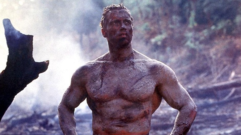 Arnold Schwarzenegger ca olandeză fără cămașă și acoperită de noroi în prădător