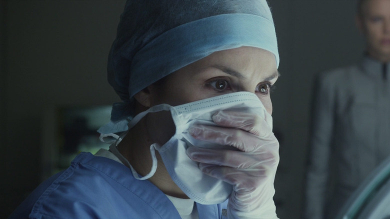 Noomi Rapace în rolul lui Elizabeth Shaw privindu -se de groază în timp ce își acoperea chipul în Prometeu