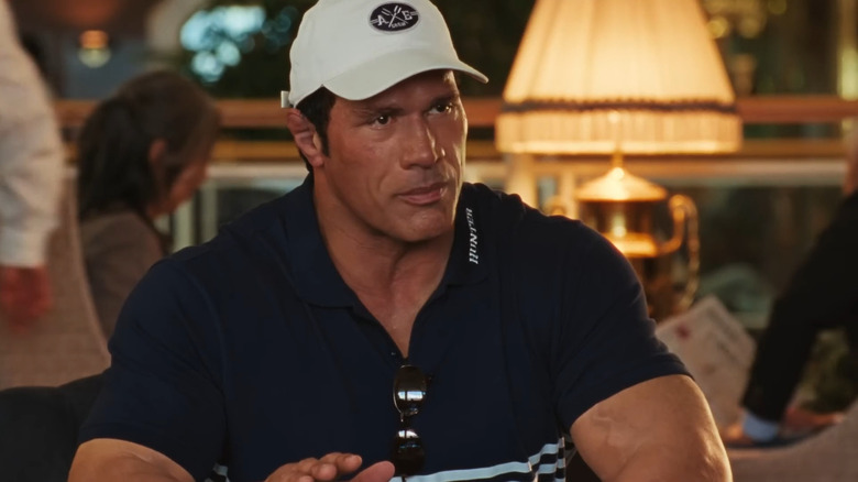 Dwayne Johnson ca Mark Kerr stând la o masă în mașina de zdrobire