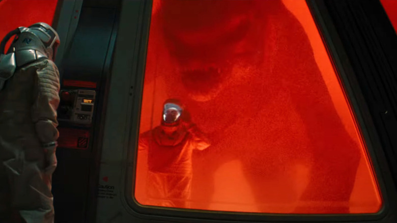 Un tehnician prins într -un laborator cu un monstru mare în spatele lui în Jurassic World: Rebirth