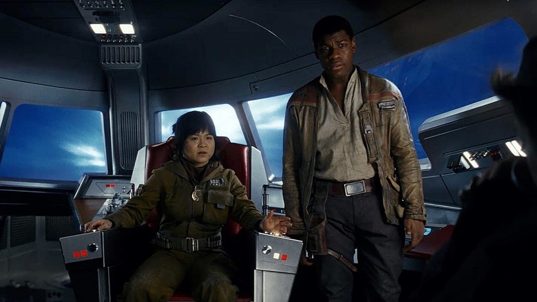 Kelly Marie Tran în timp ce Rose Tico stătea pe un scaun de cabină în timp ce John Boyega în timp ce Finn stă lângă ea în Star Wars: The Last Jedi