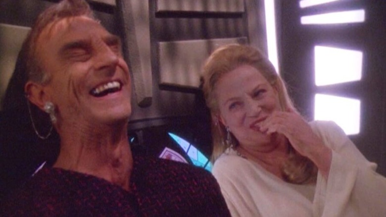 Marc Alaimo ca Gul Dukat în forma Bajoran și Louise Fletcher ca Kai Winn, râzând împreună, pe Star Trek: Deep Space Nine
