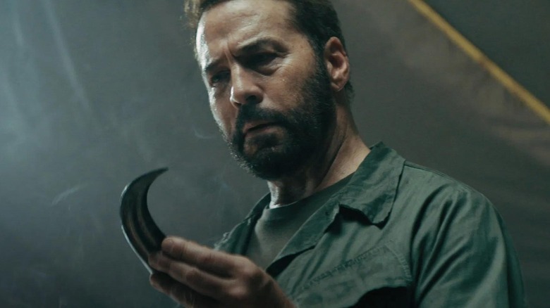 Jeremy Piven în calitate de Ierihon care ținea o gheare Raptor în războiul primitiv