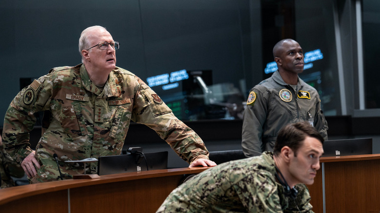 Generalul Anthony Brody și personalul său anxiosul observă un monitor într -o casă de dinamită