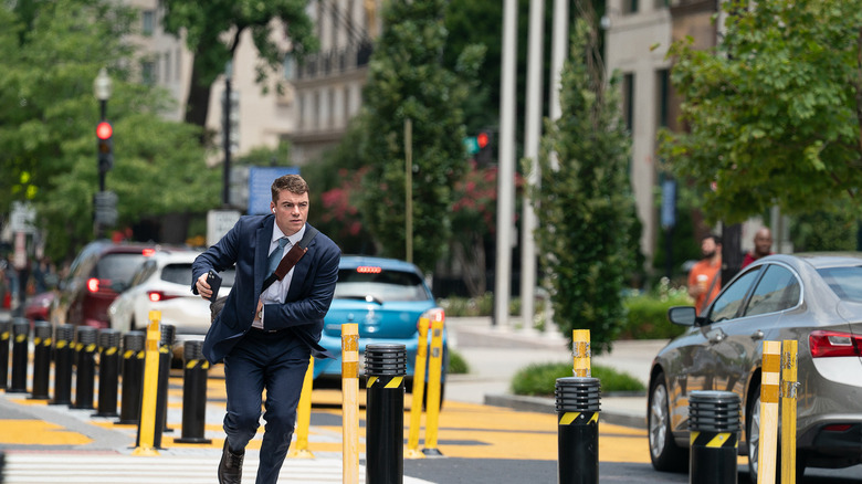 Jake Baerington aleargă pe stradă cu telefonul în mână într -o casă din Dynamite