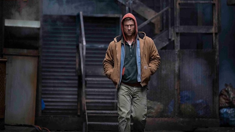 Glen Powell ca Ben Richards mergând și purtând o glugă în The Running Man (2025)