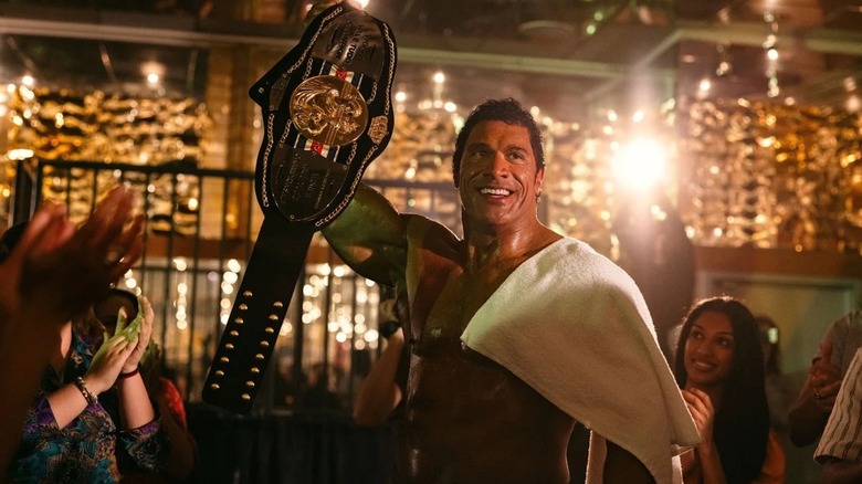 Dwayne Johnson în calitate de Mark Kerr ridică o centură de campionat în mașina de zdrobire